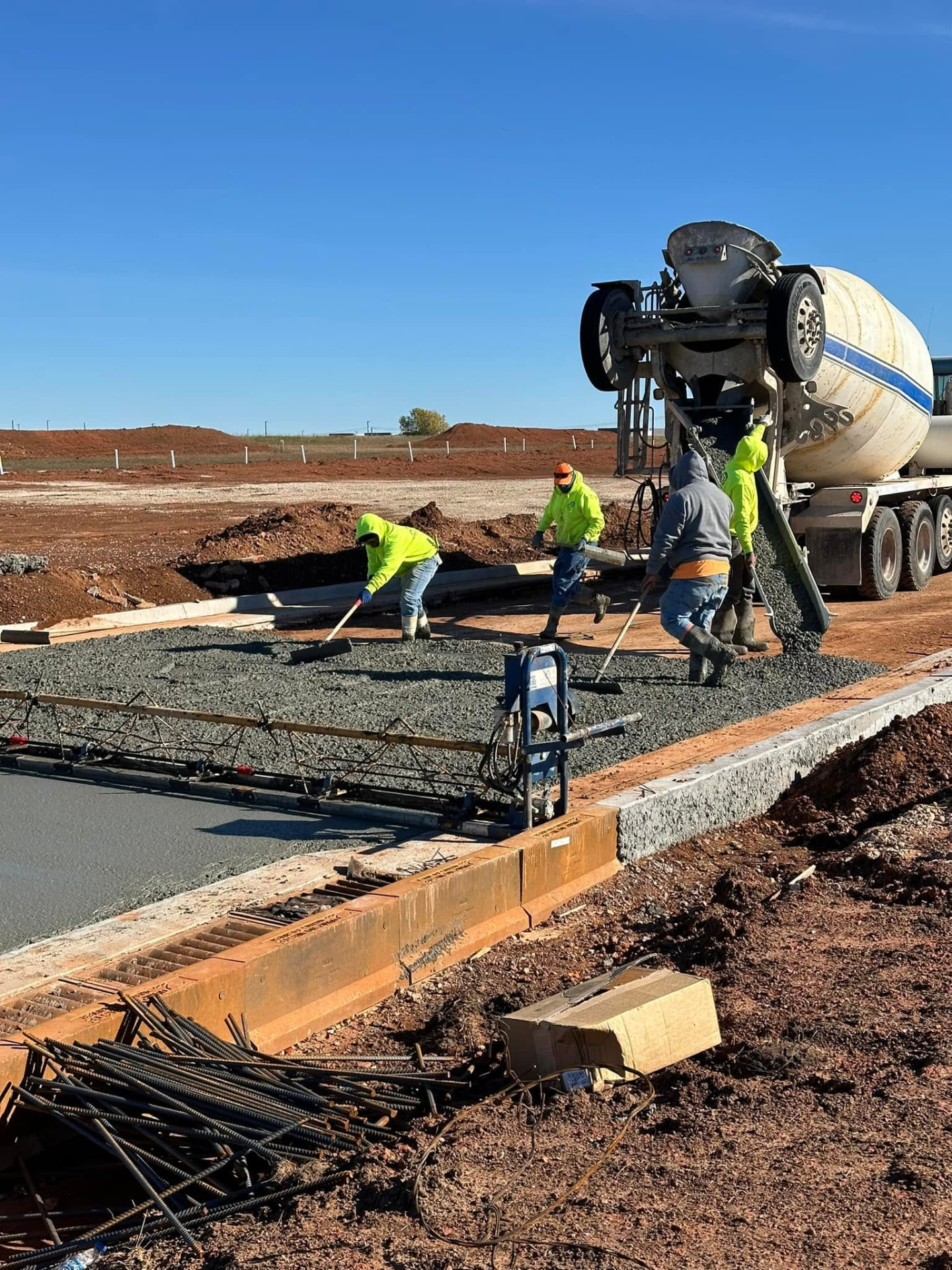 Skid steer grading base material ahead of a concrete pour