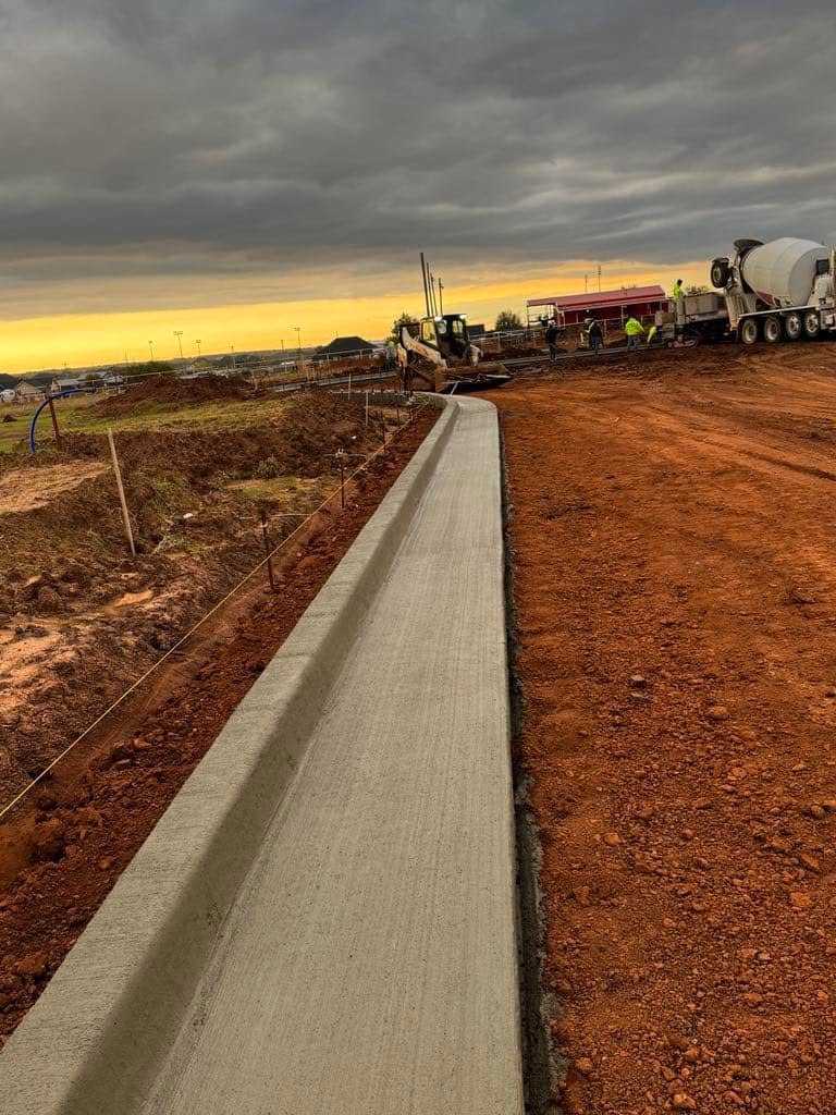 Finishing a freshly poured concrete curb at a roadway job site